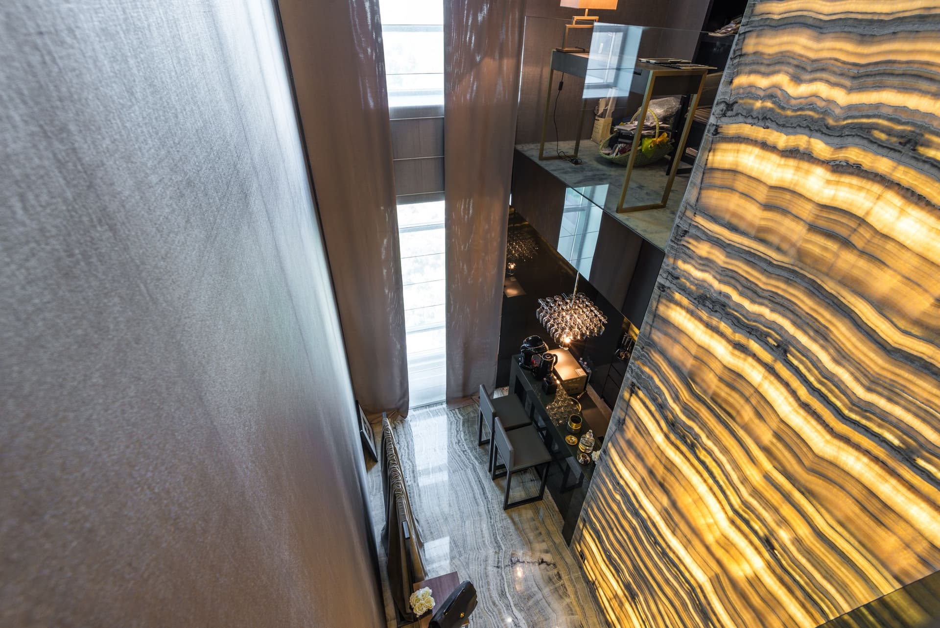 A luxury interior with a backlit golden onyx marble feature wall.