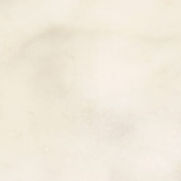 Afyon White marble slab face, photographed for the factory catalog — near-white amber overall.